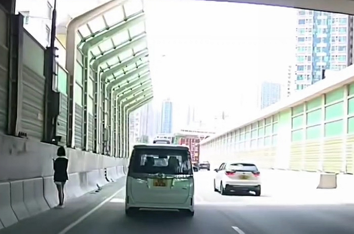 有片〡少女呆站公路路肩睇手機 網民：比仔趕落車
