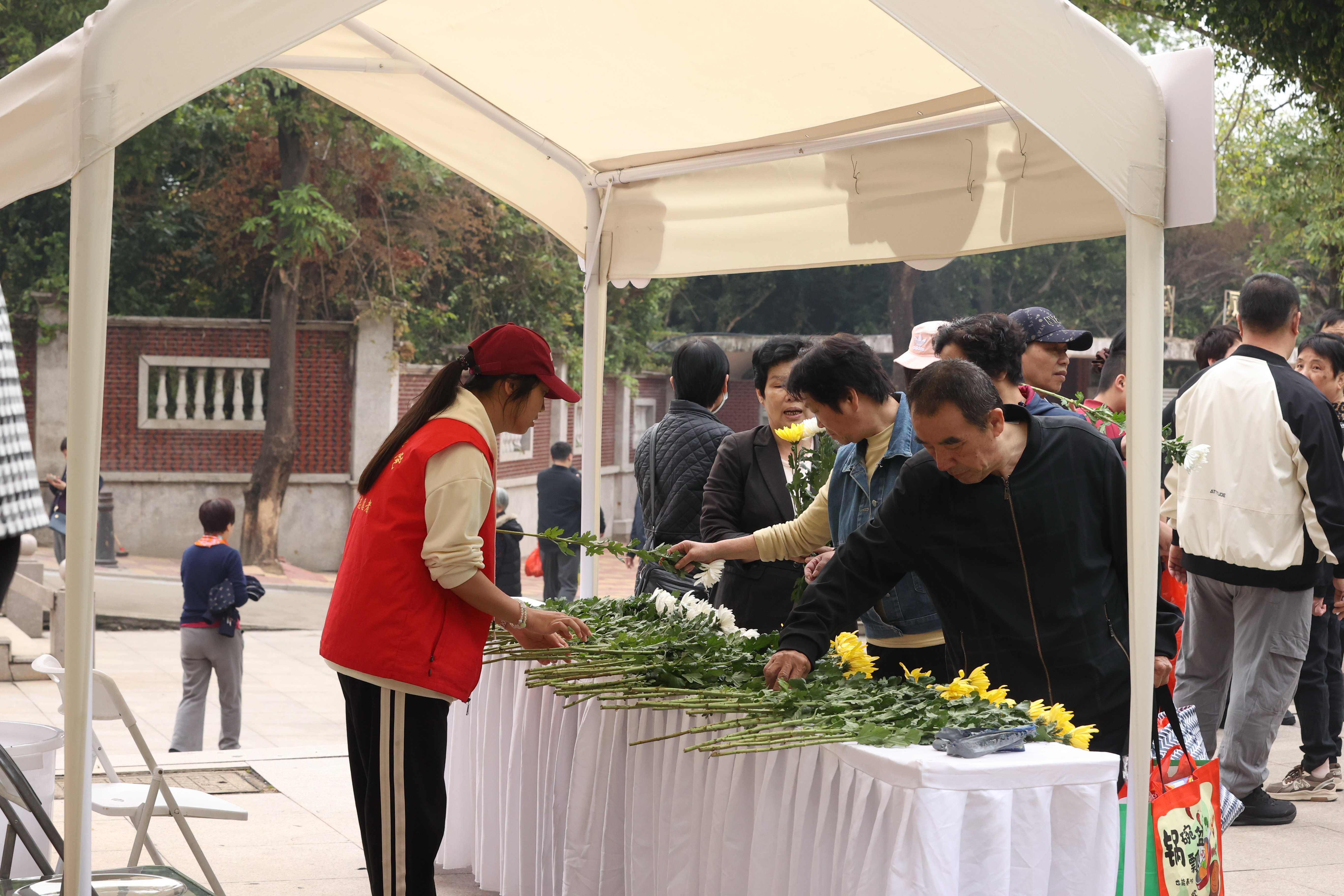 圖四：志願者在宏福園服務點幫助前來祭掃的人員送水送鮮花 （胡彥明 攝）.jpg