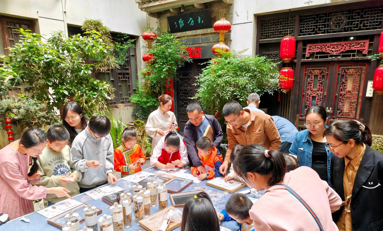 圖3：黨員代表領著孩子們在四方家四合院裏親手體驗方劑配伍.jpg