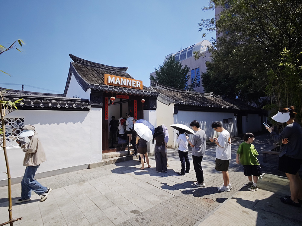 圖3：7月31日開業當天，MANNER南通門店出杯量即位列全國第一。圖為烈日高溫下，排隊人潮蜿蜒至院門之外.jpg